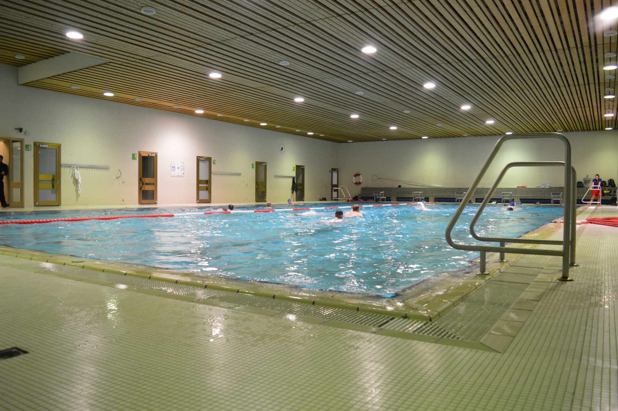 Aufnahme des beleuchteten Viechtacher Hallenbads, in dem mehrere Schwimmer ihre Bahnen ziehen.